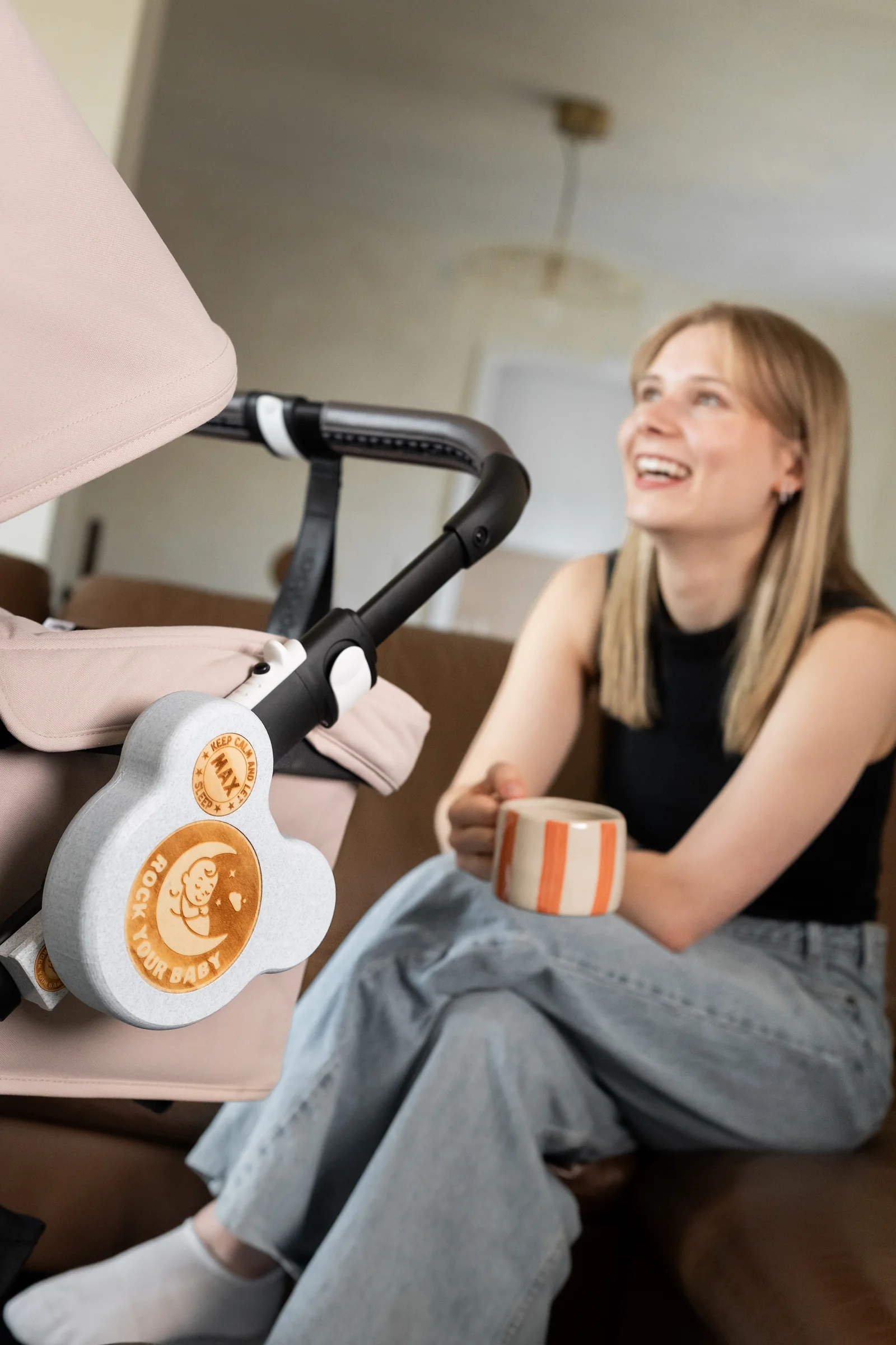 Eine Mutter mit einer Tasse neben einem Kinderwagen
