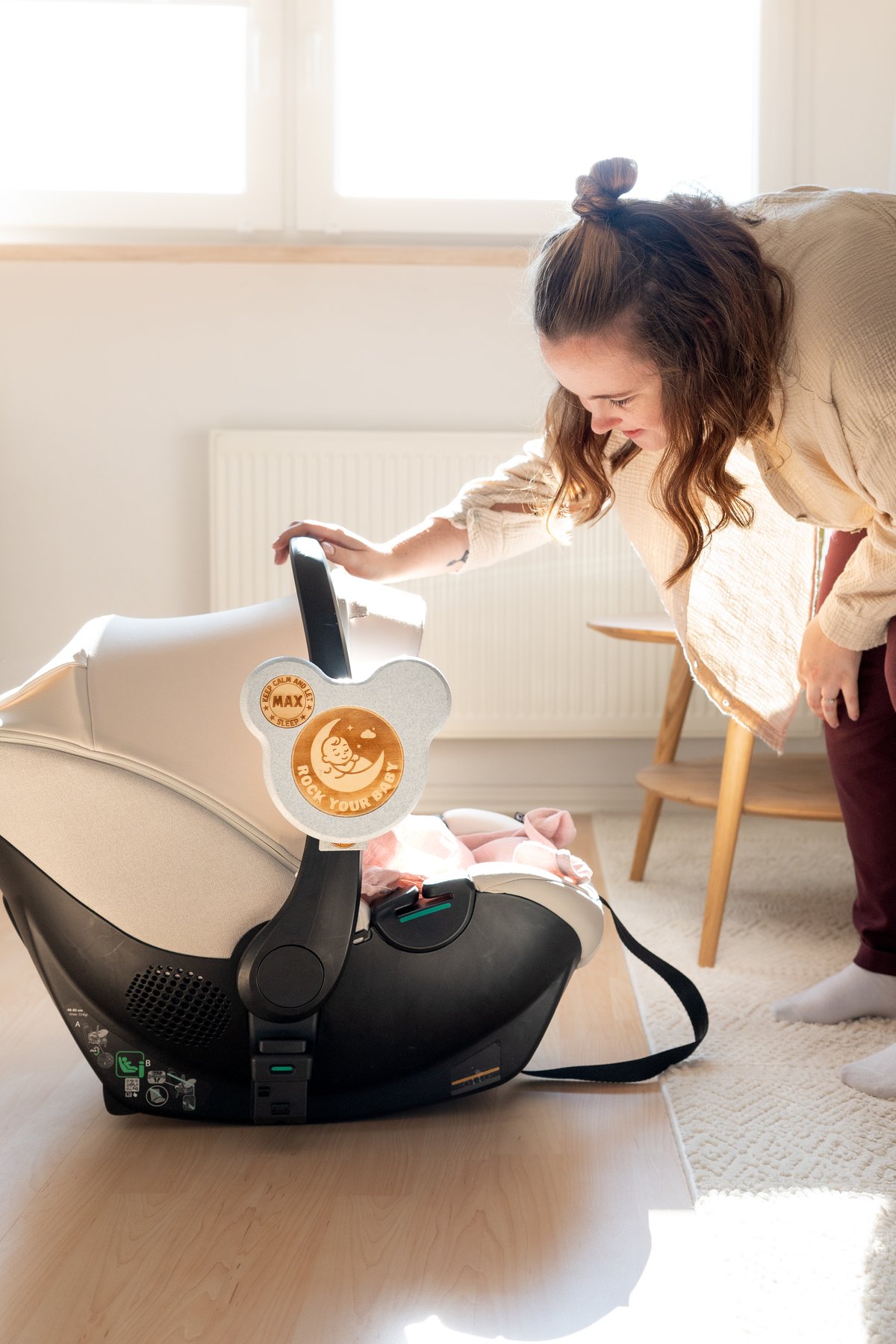 Eine Mutter schaut nach ihrem Baby in der Babyschale, nachdem die Familie zu Hause angekommen ist.